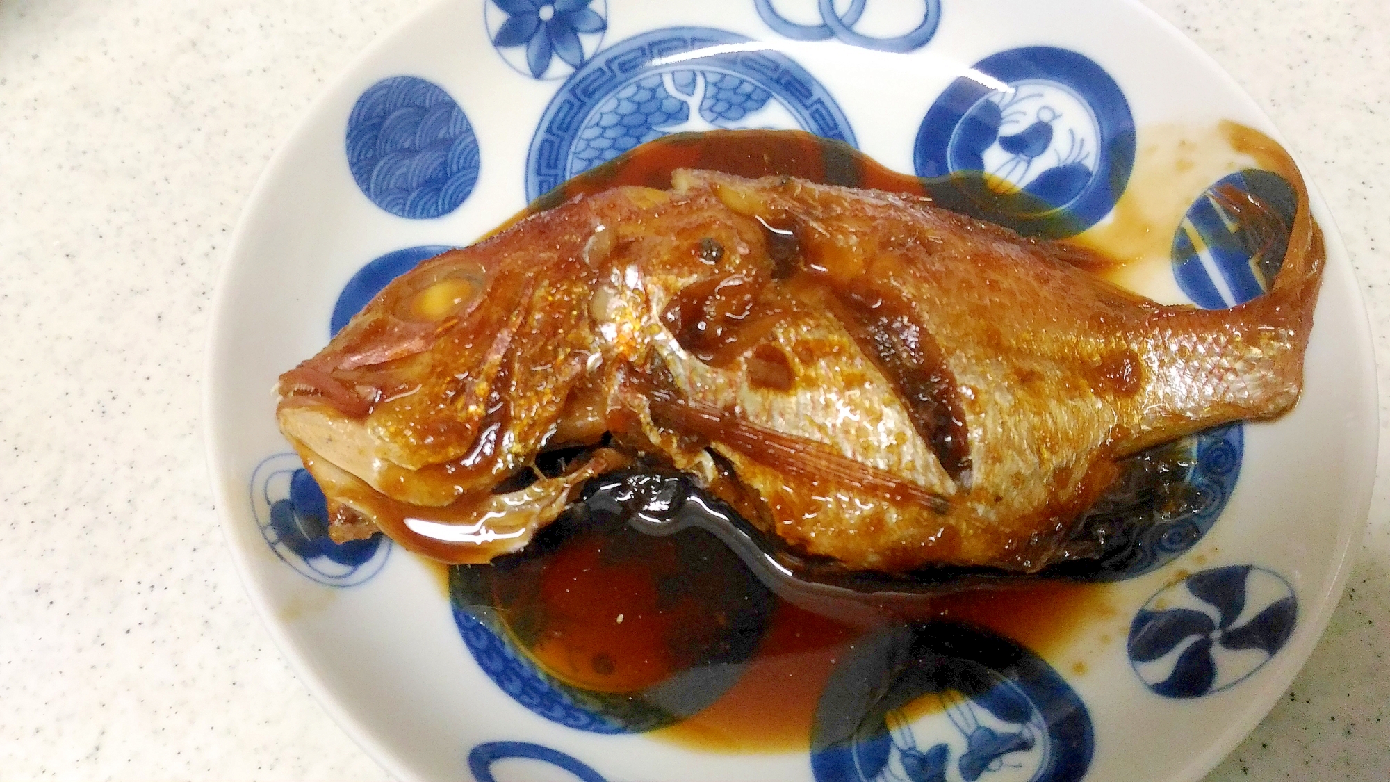 青と白のお皿に盛り付けられた連子鯛のしょうが風味煮付け