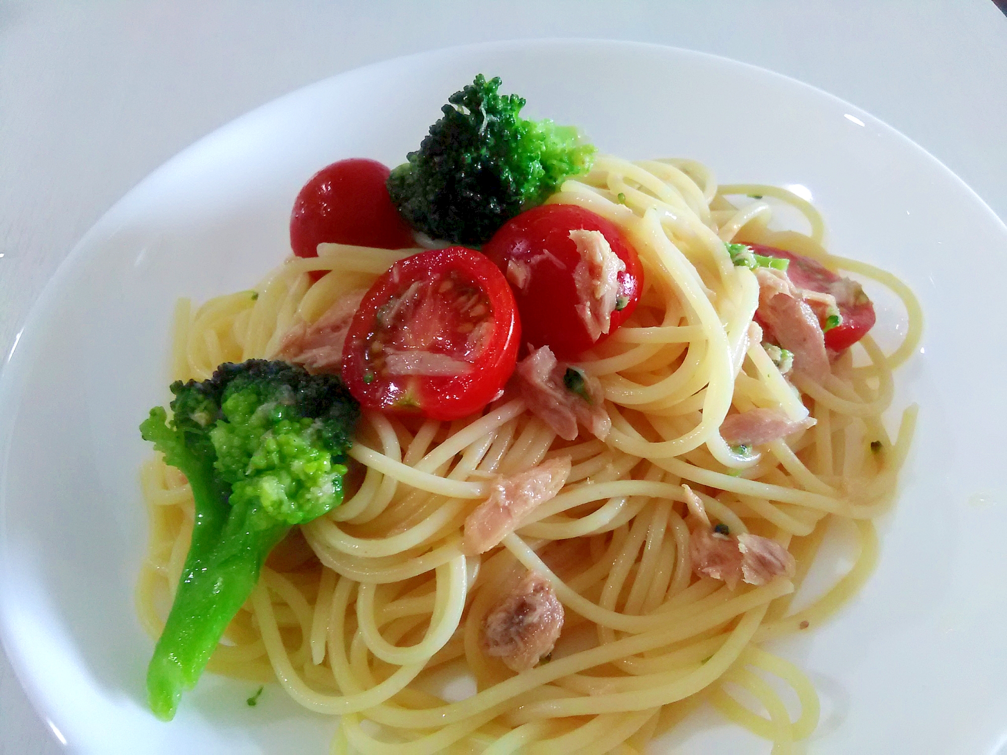 白い皿に盛られた、ツナとトマトとブロッコリーの冷製パスタ