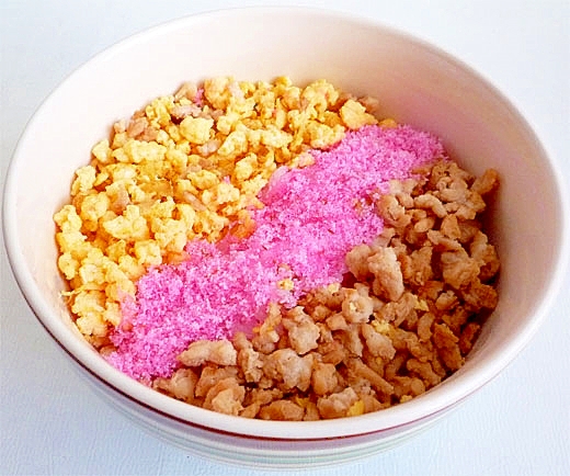 白い丼に盛り付けられた桜でんぶ入りの三食丼