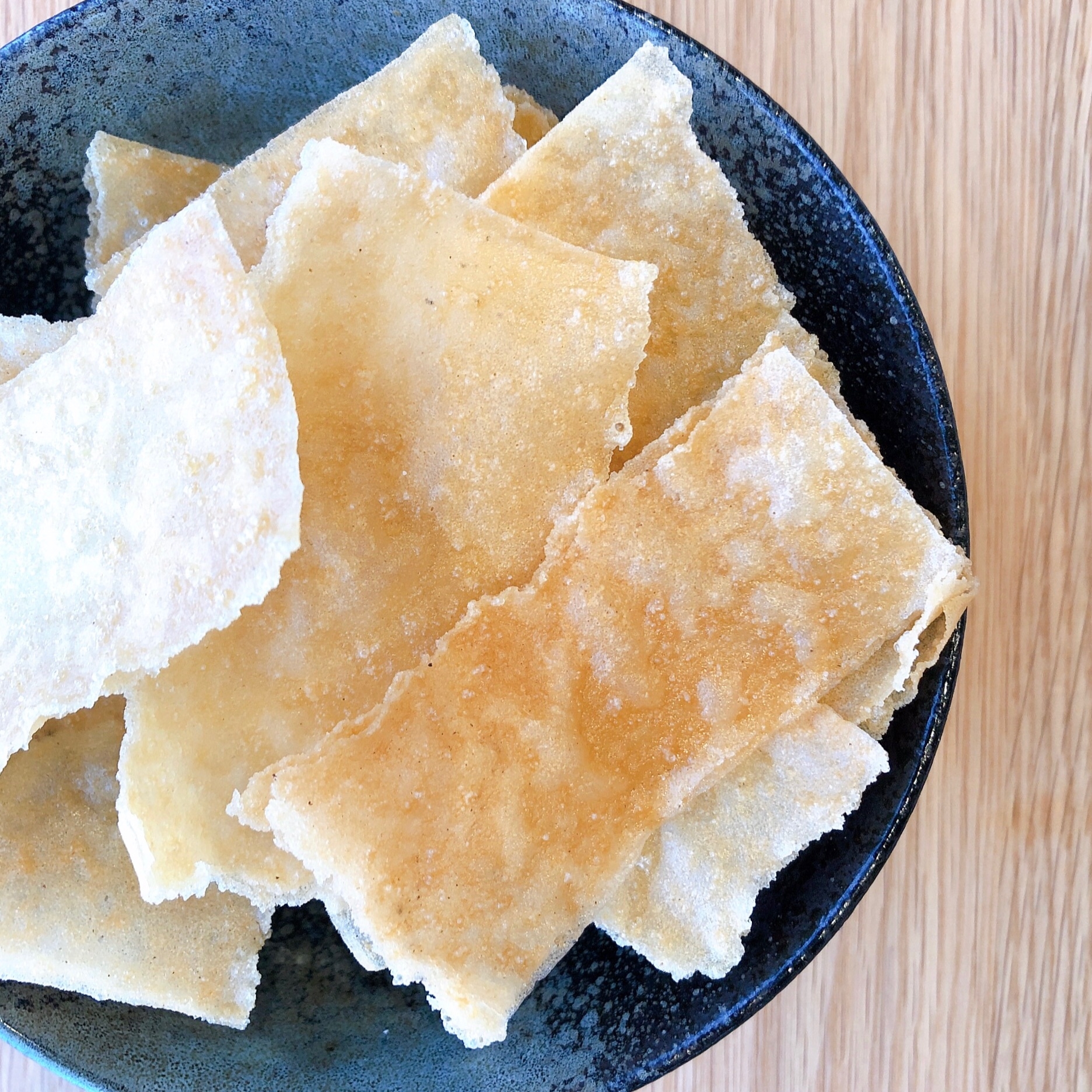 黒い皿に盛られた春巻きの皮のおつまみスティック