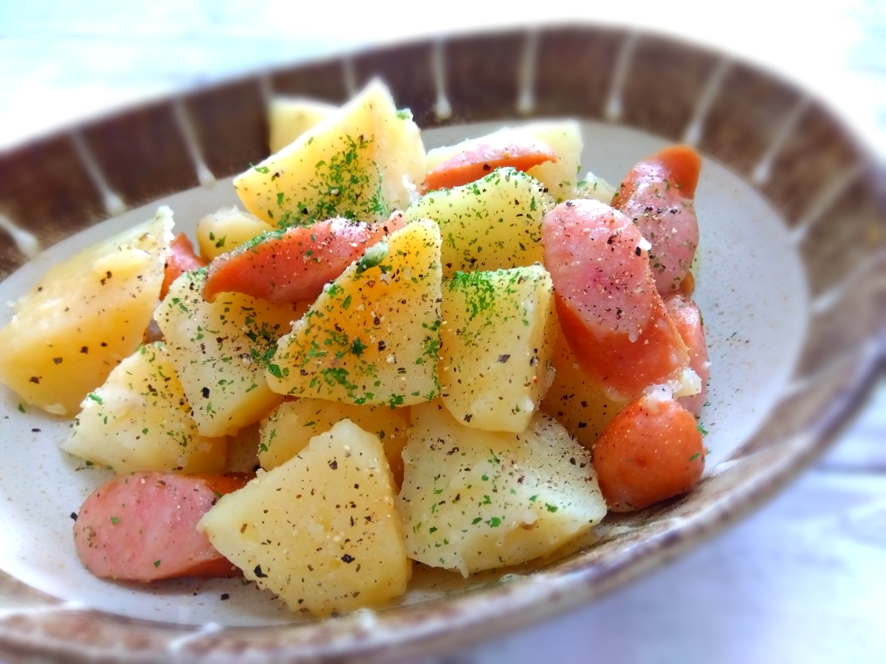 茶色の皿に盛り付けたジャーマンポテト