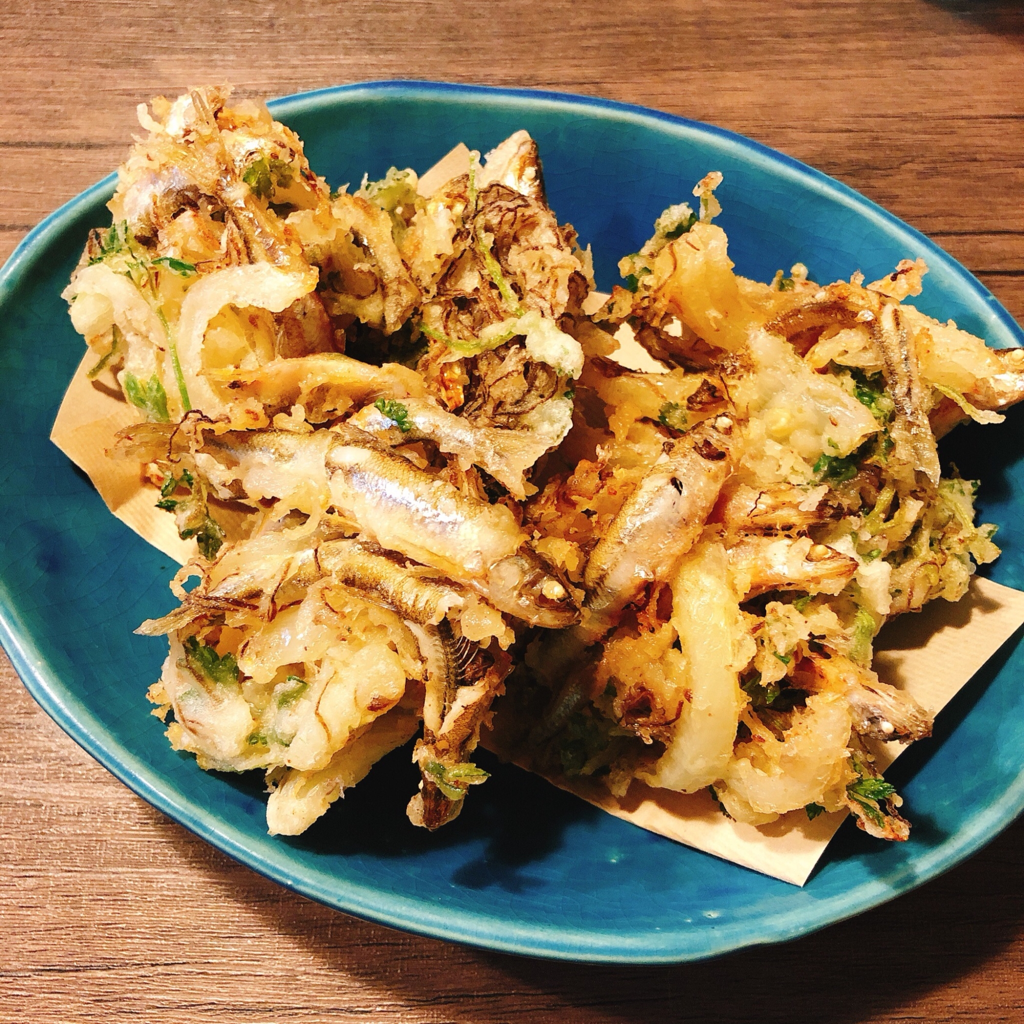 水色の皿に盛り付けられたわかさぎと玉ねぎのかき揚げ