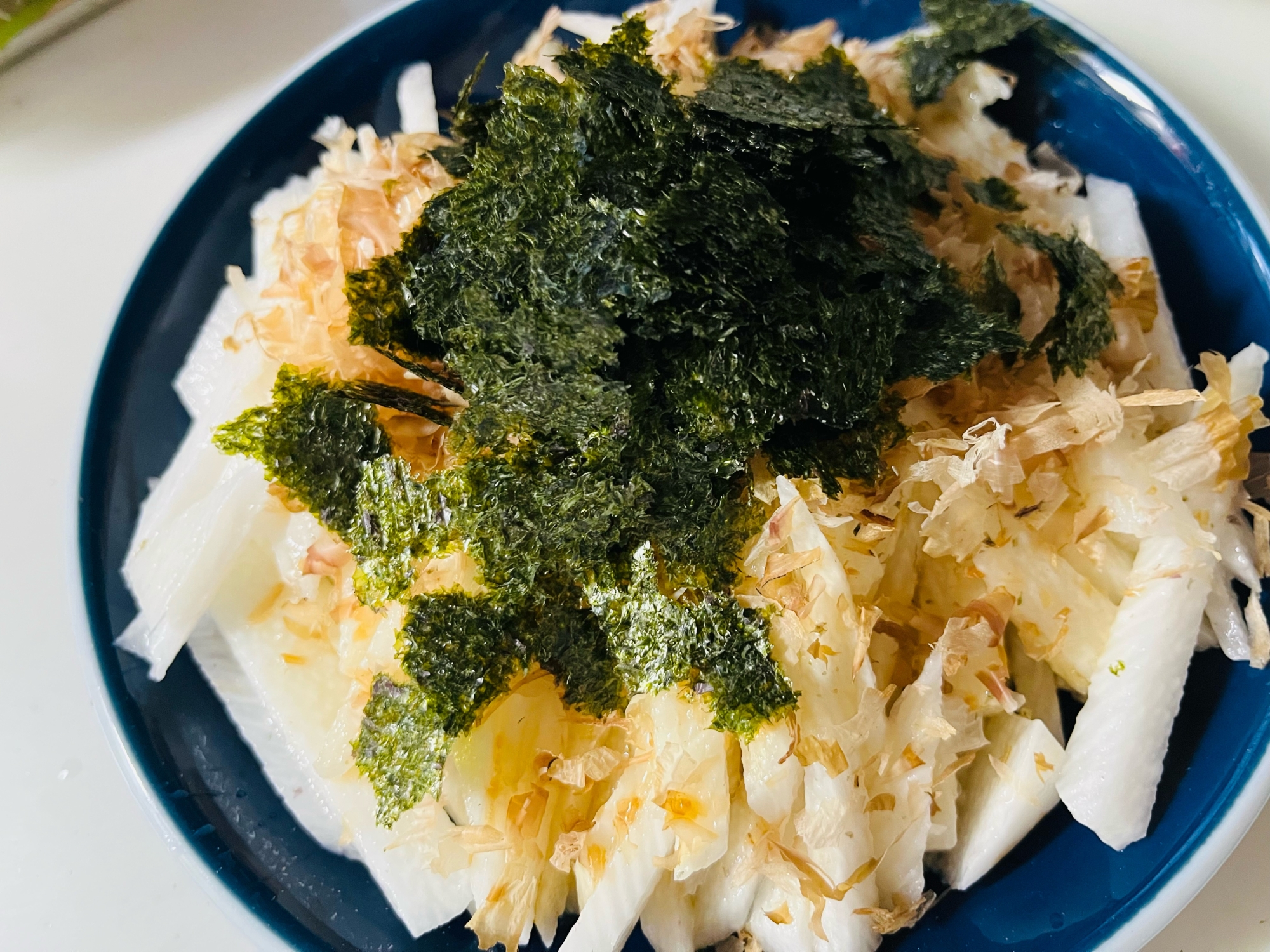 紺色の皿に盛り付けた山芋のおかかのりポン酢しょうゆ