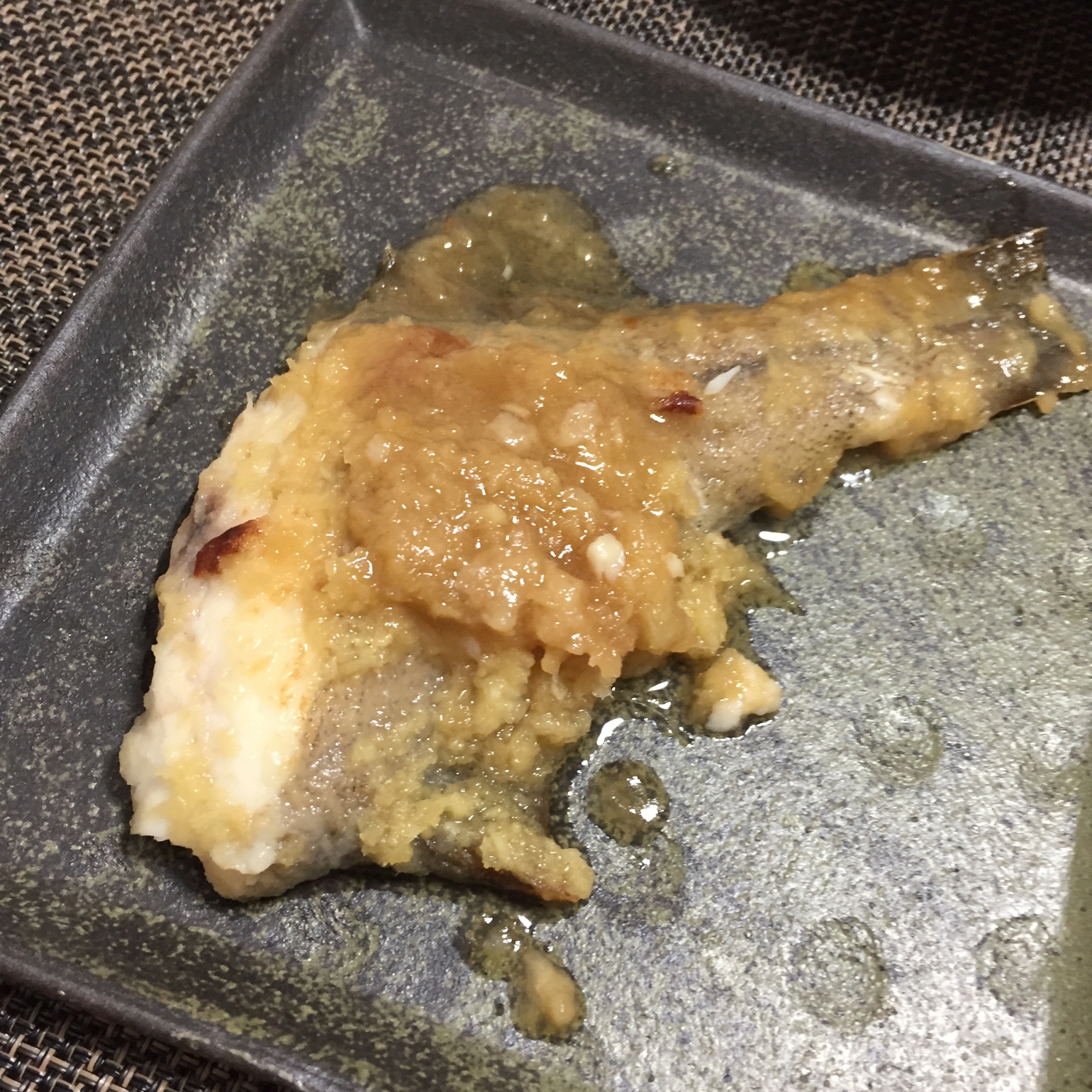 黒い皿に入ったかれいのしょうがソテー