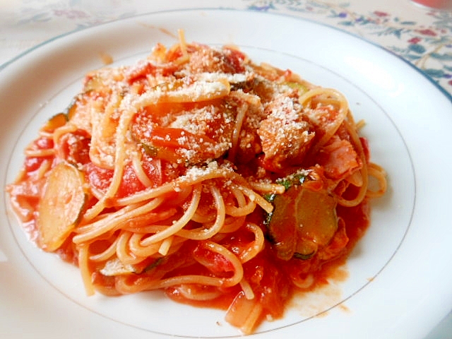 白色の丸皿に盛られたズッキーニとベーコンのトマトパスタ