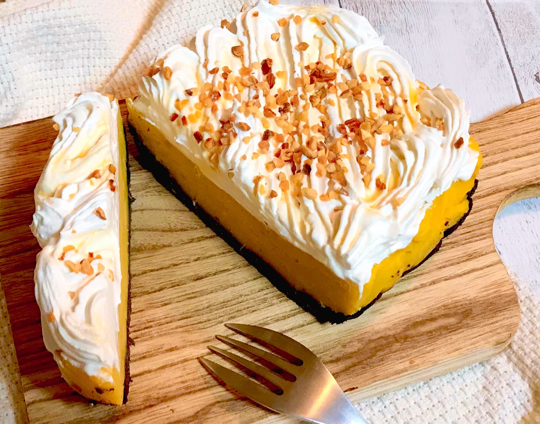 カッティングボードの上にある、スイートポテトタルトの生クリームのせ