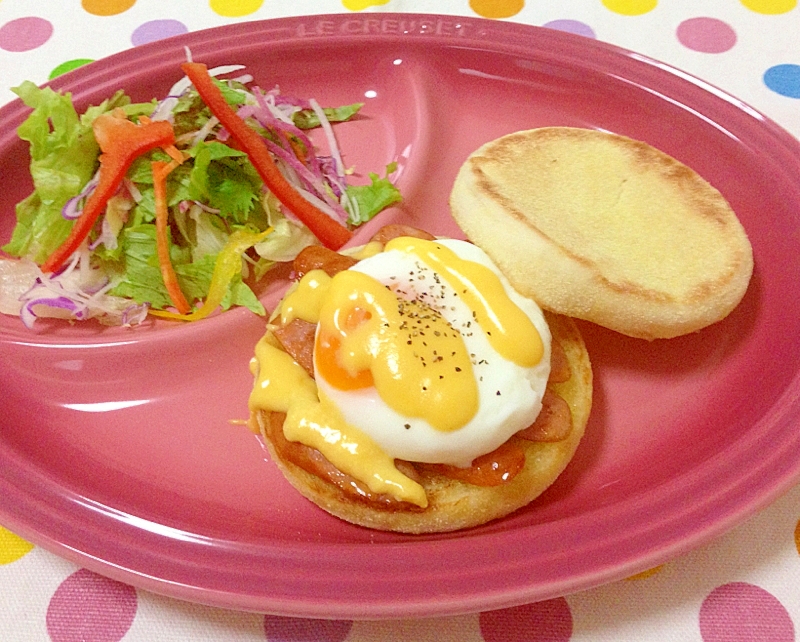 ピンクのプレートにのせられたサラダとエッグベネディクト風マフィン
