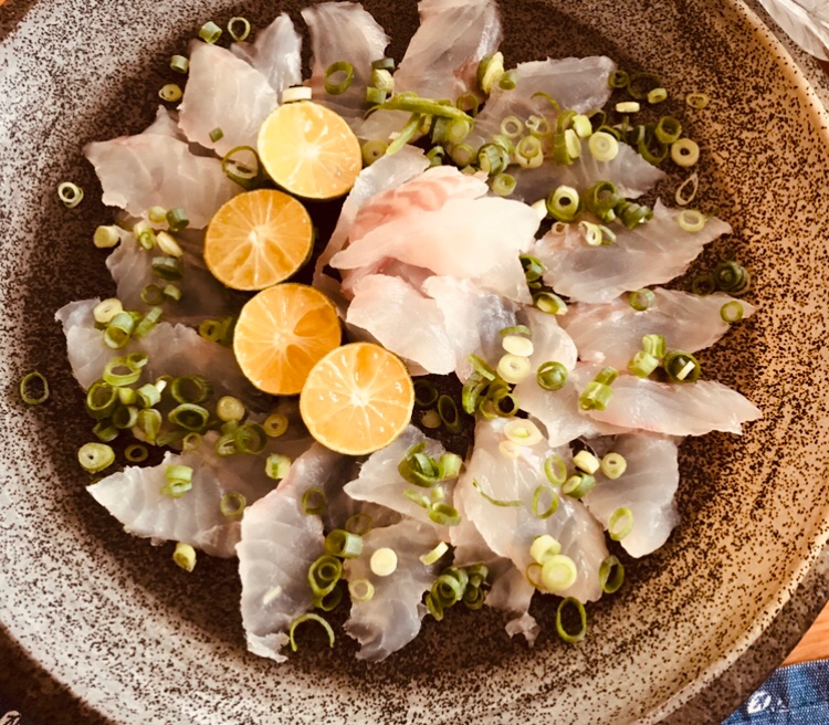 茶色い皿に盛られたキジハタアコウのカルパッチョ
