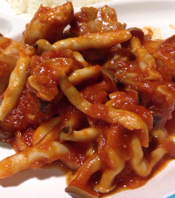 白い皿に盛り付けた鶏肉のガーリックトマト煮