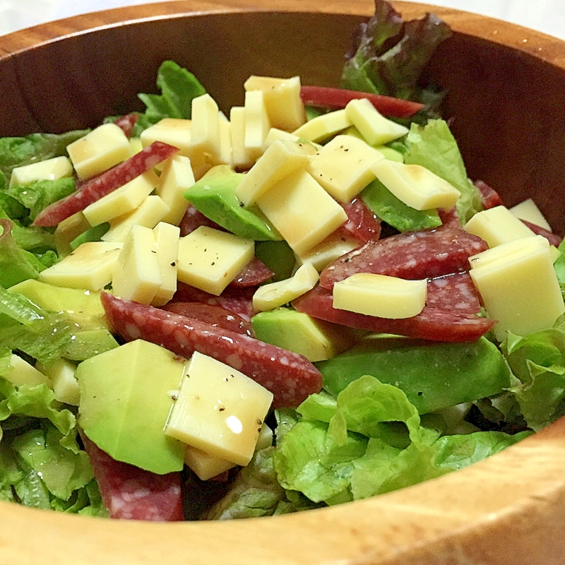 木製の器に盛られたアボカドとサラミのおつまみサラダ