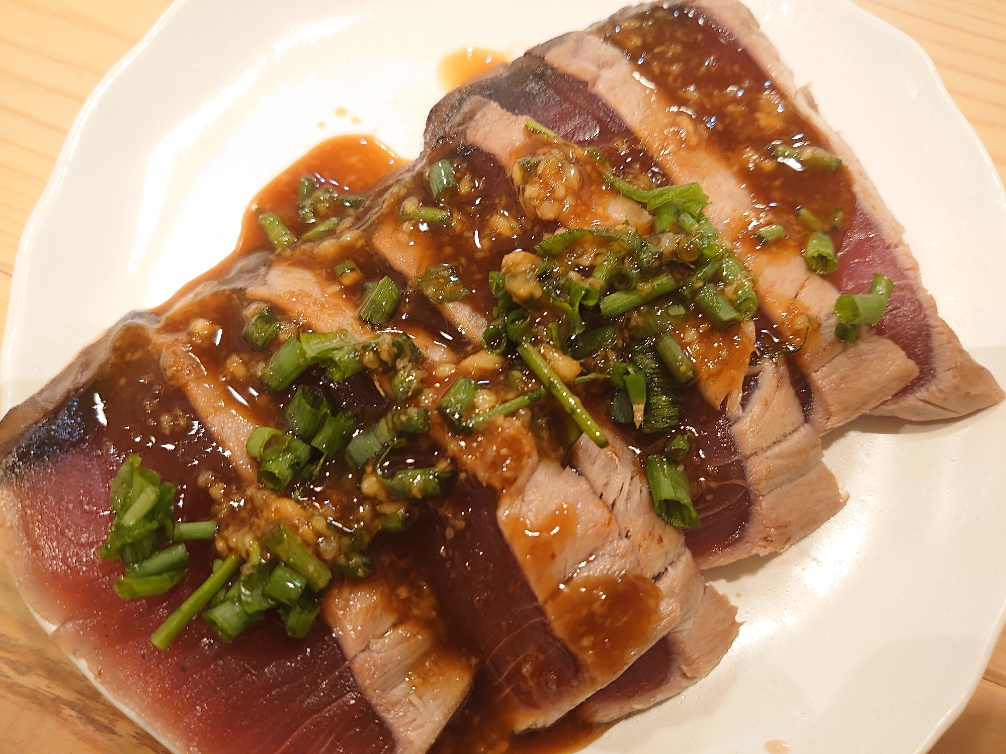 かつおの刺身に芽ねぎソースがのっている様子