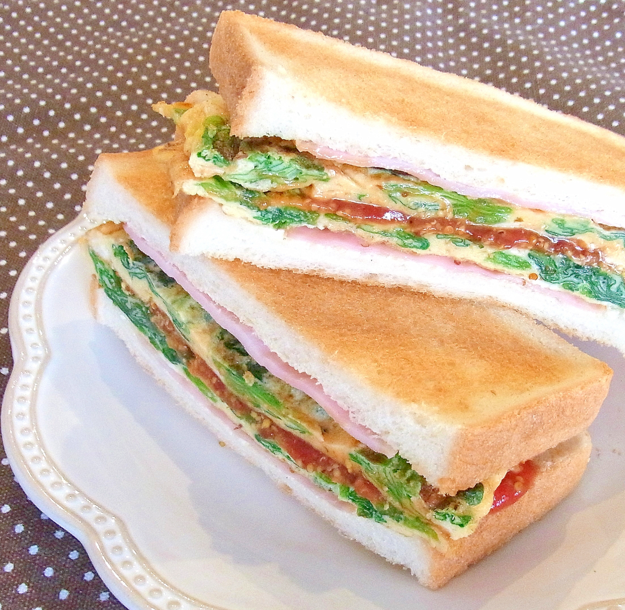 白い皿に盛り付けたほうれん草オムレツトーストサンド