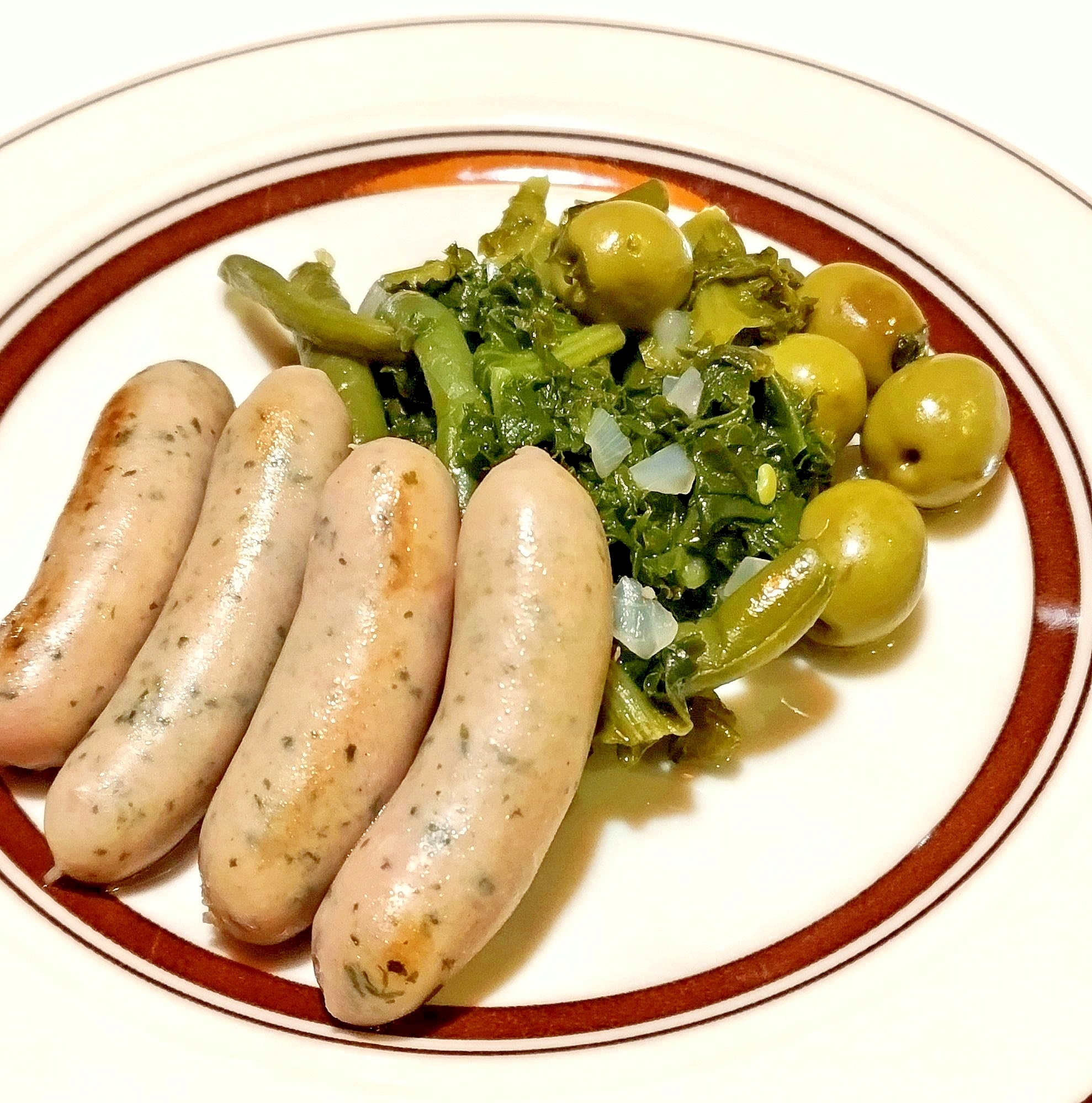 丸皿に盛り付けたソーセージとエンダイブの蒸し煮