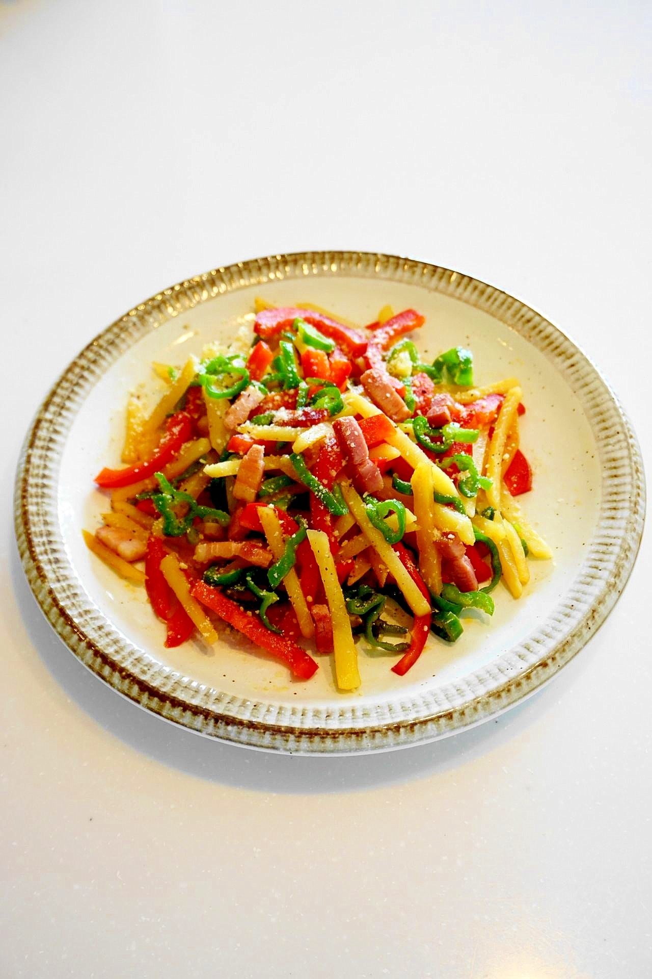 ピーマンとパプリカとポテトとベーコンのコンソメ炒め