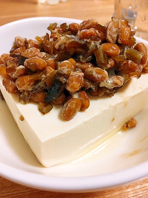 白い皿に盛り付けられた納豆と山椒の佃煮をのせた冷奴