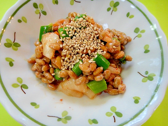 緑色の葉の絵が描かれた丸皿に盛られた冷凍アスパラとキムチの納豆和え