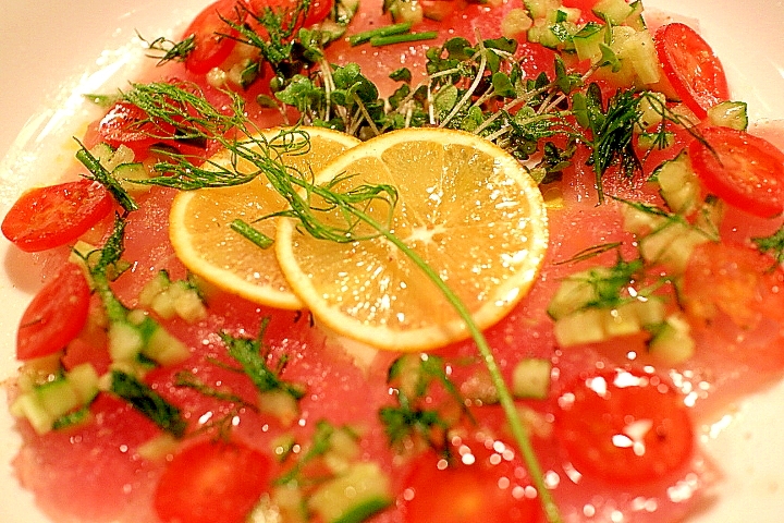 白いお皿に盛られたびんちょうまぐろのカルパッチョ