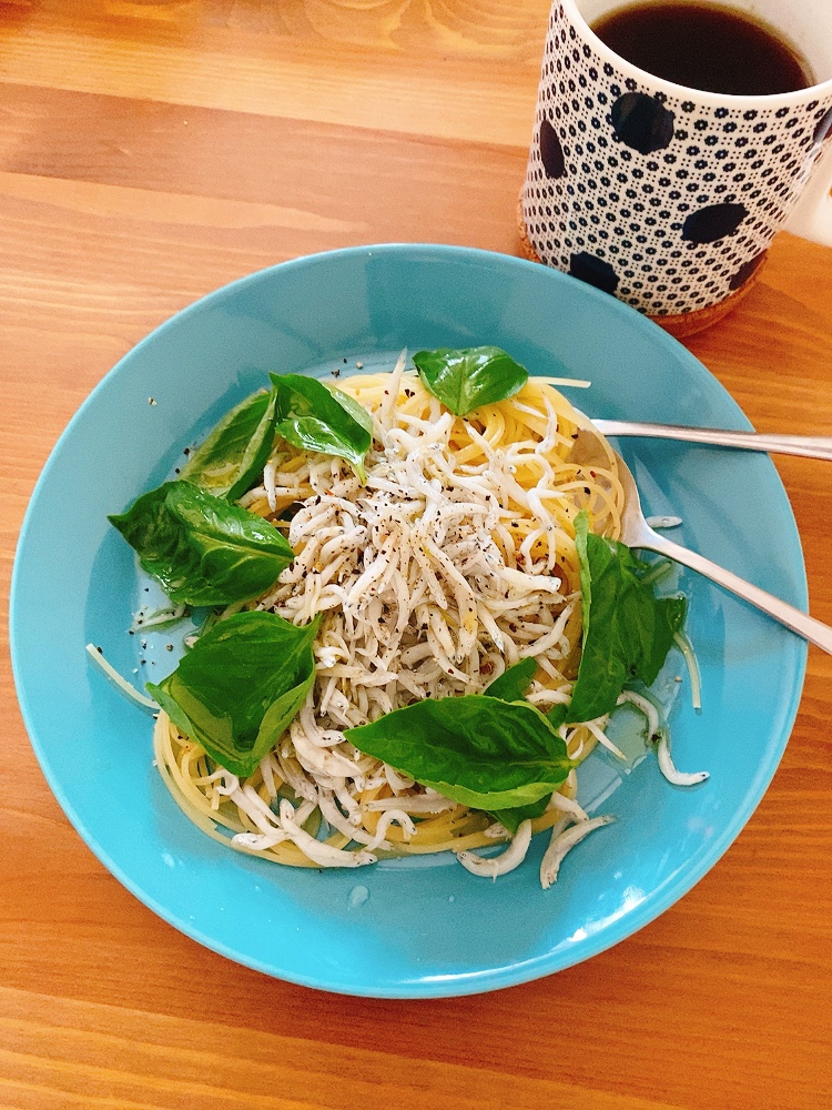 青い皿にしらすとバジルのパスタが盛り付けられている