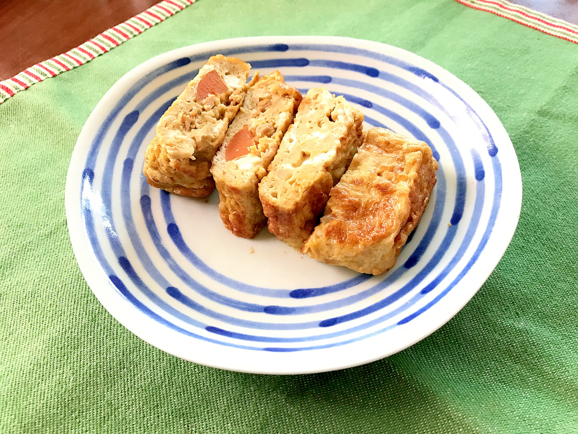 青色の模様が入った丸皿に盛られたカレー卵焼き