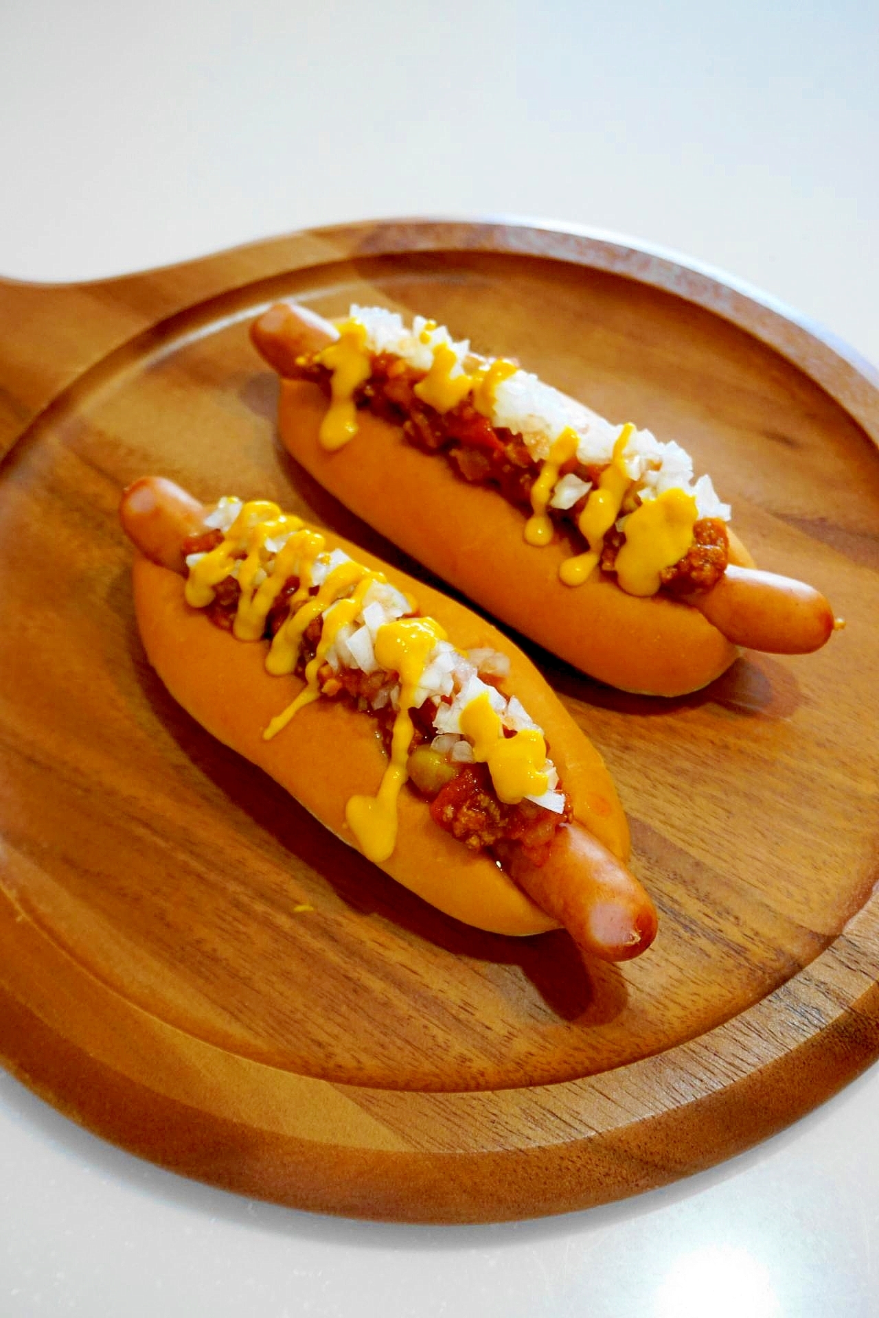 木皿に盛り付けられたチリコンカン入りホットドッグ