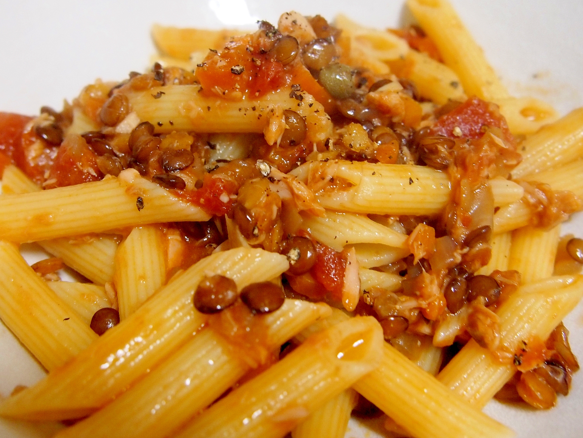 白いお皿に盛り付けられたツナとレンズ豆のトマトソースパスタ