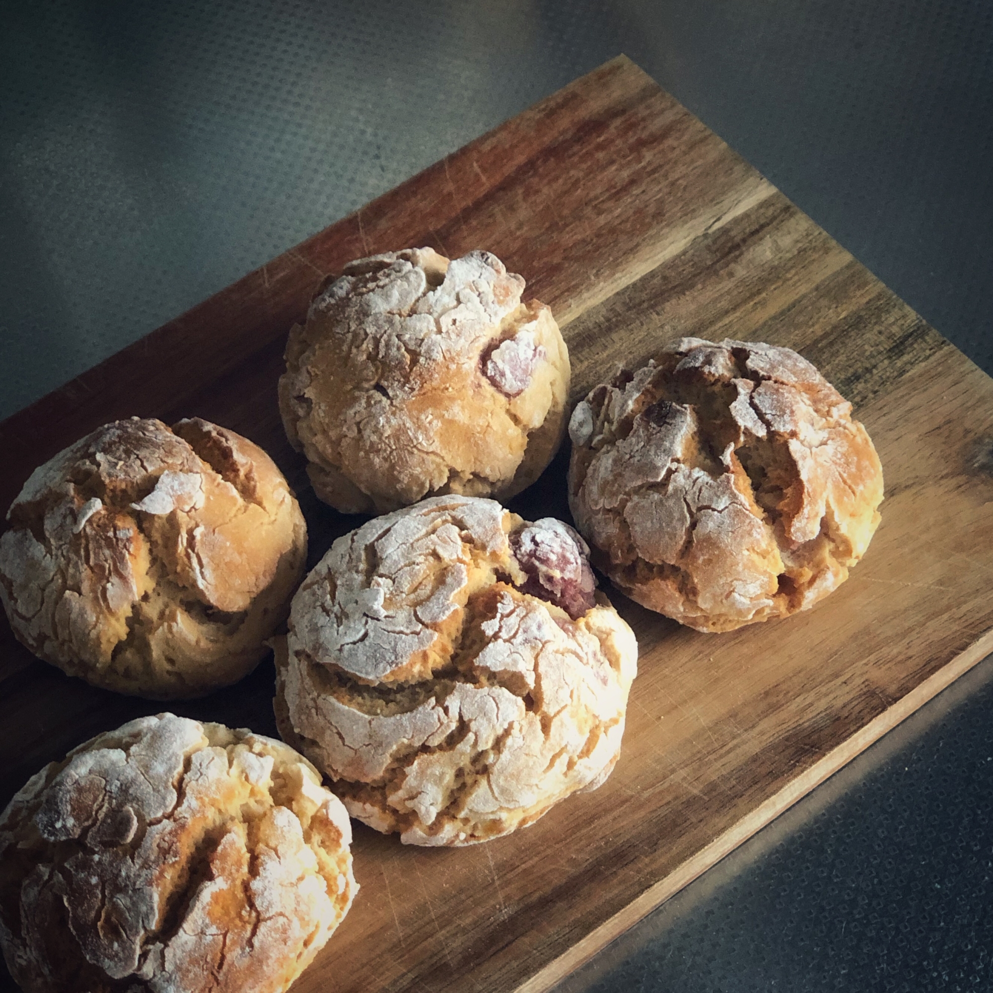 カッティングボードにのせたいちごとバナナのまんまるパン