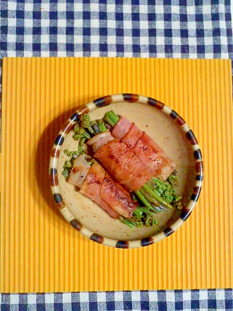 茶色いお皿に盛り付けられたわらびのベーコン巻き