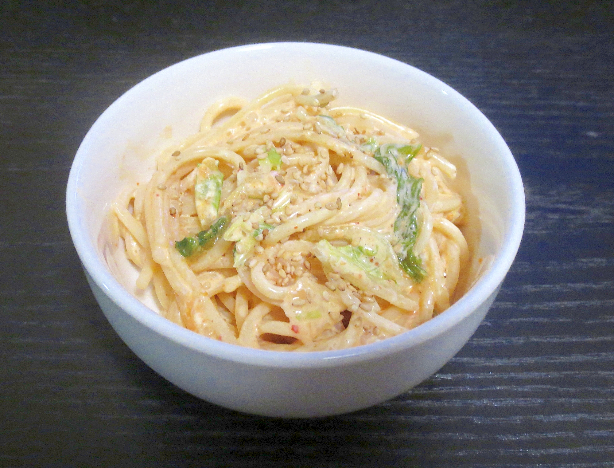 白い器に盛られたキムチを使うサラスパ