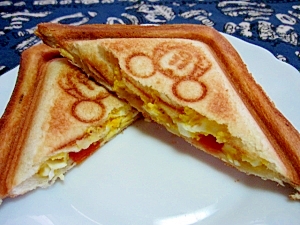 白い皿にのせた卵とトマトのホットサンド