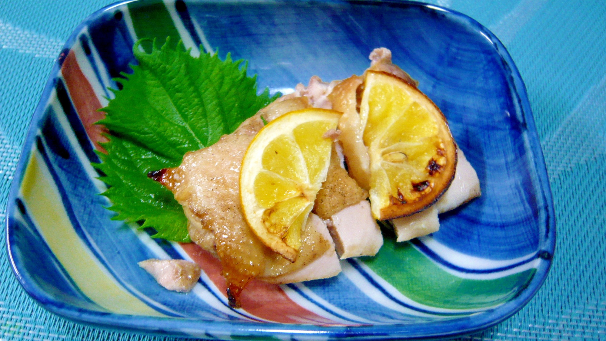 レモン香るグリルチキンが青い皿に盛り付けられているところ