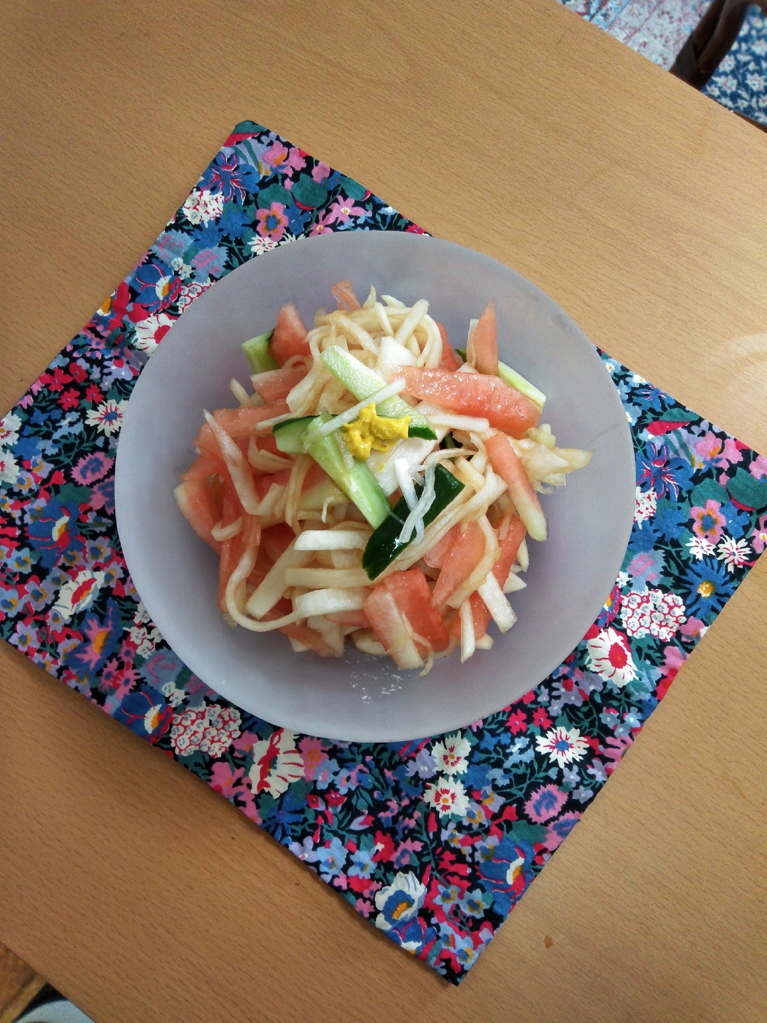 白い丸皿に盛り付けたスイカときゅうりの和え物