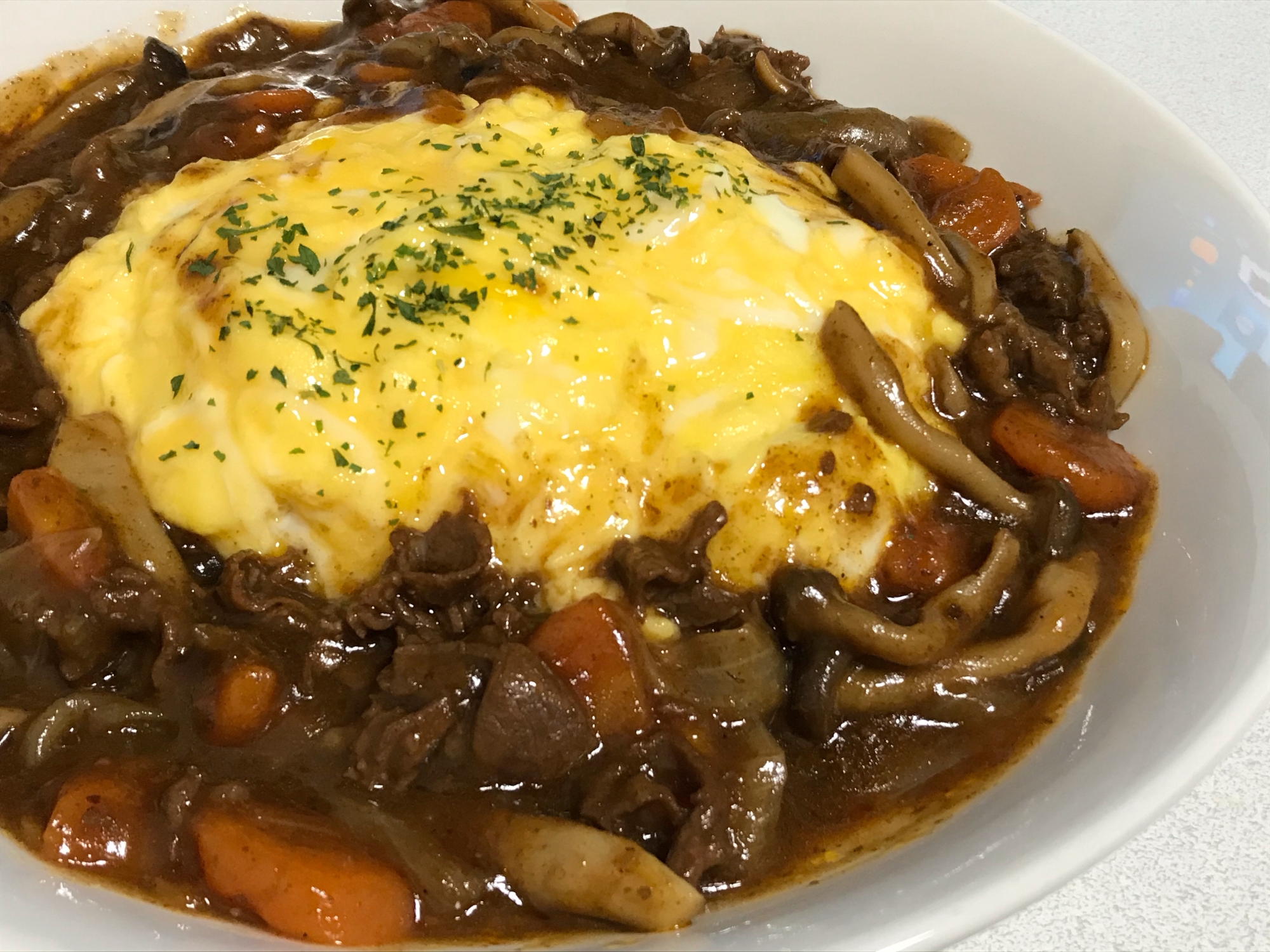 白い皿に盛り付けたハヤシソースのオムハヤシ