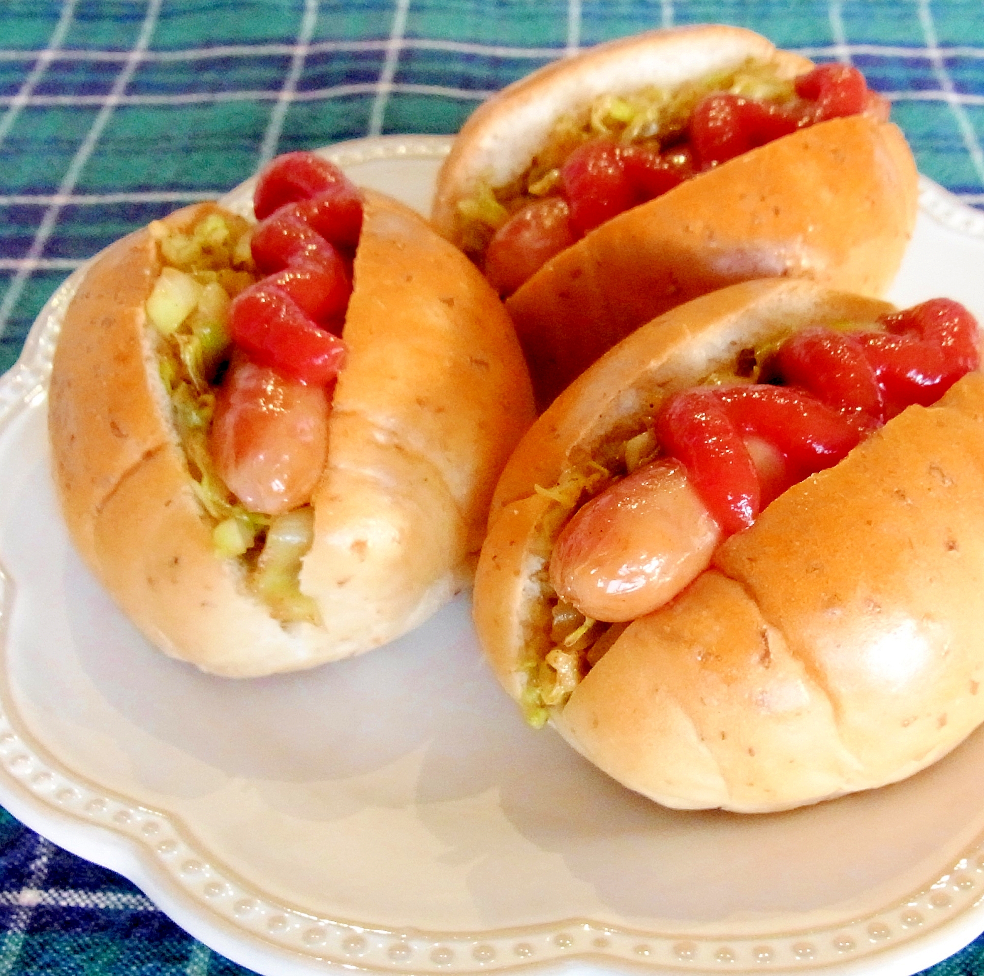 白い皿に盛られたウインナーキャベツのロールパンサンド