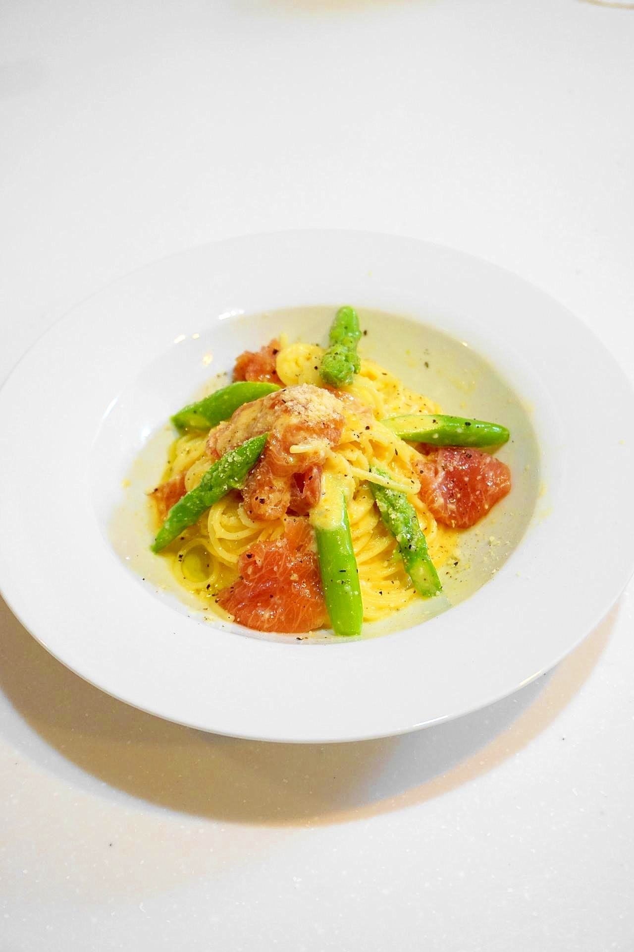 白い丸皿に盛り付けたアスパラと生ハムのフェデリーニ