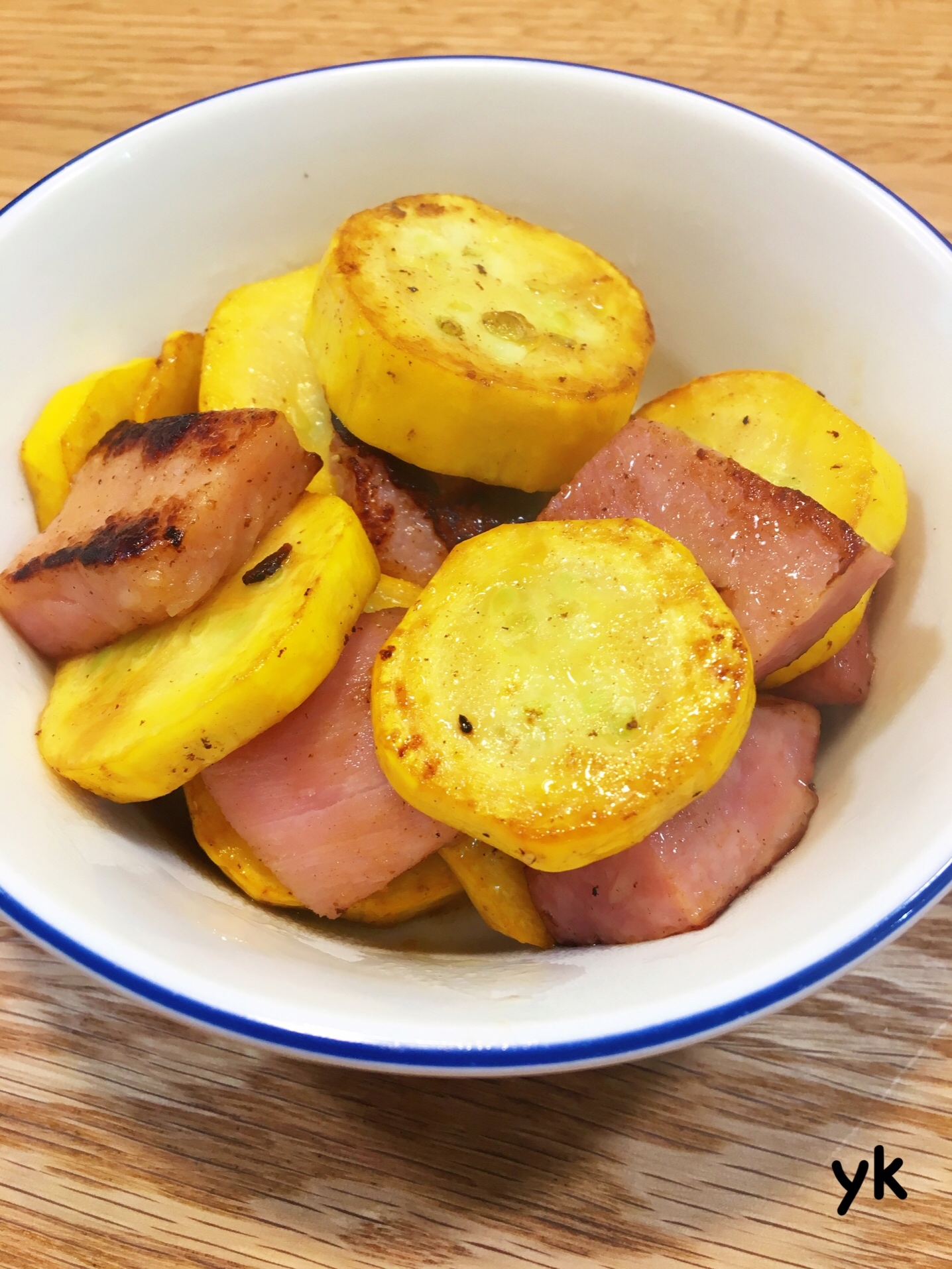 青色の縁取りの皿に盛られたズッキーニとベーコンのポン酢しょうゆ炒め