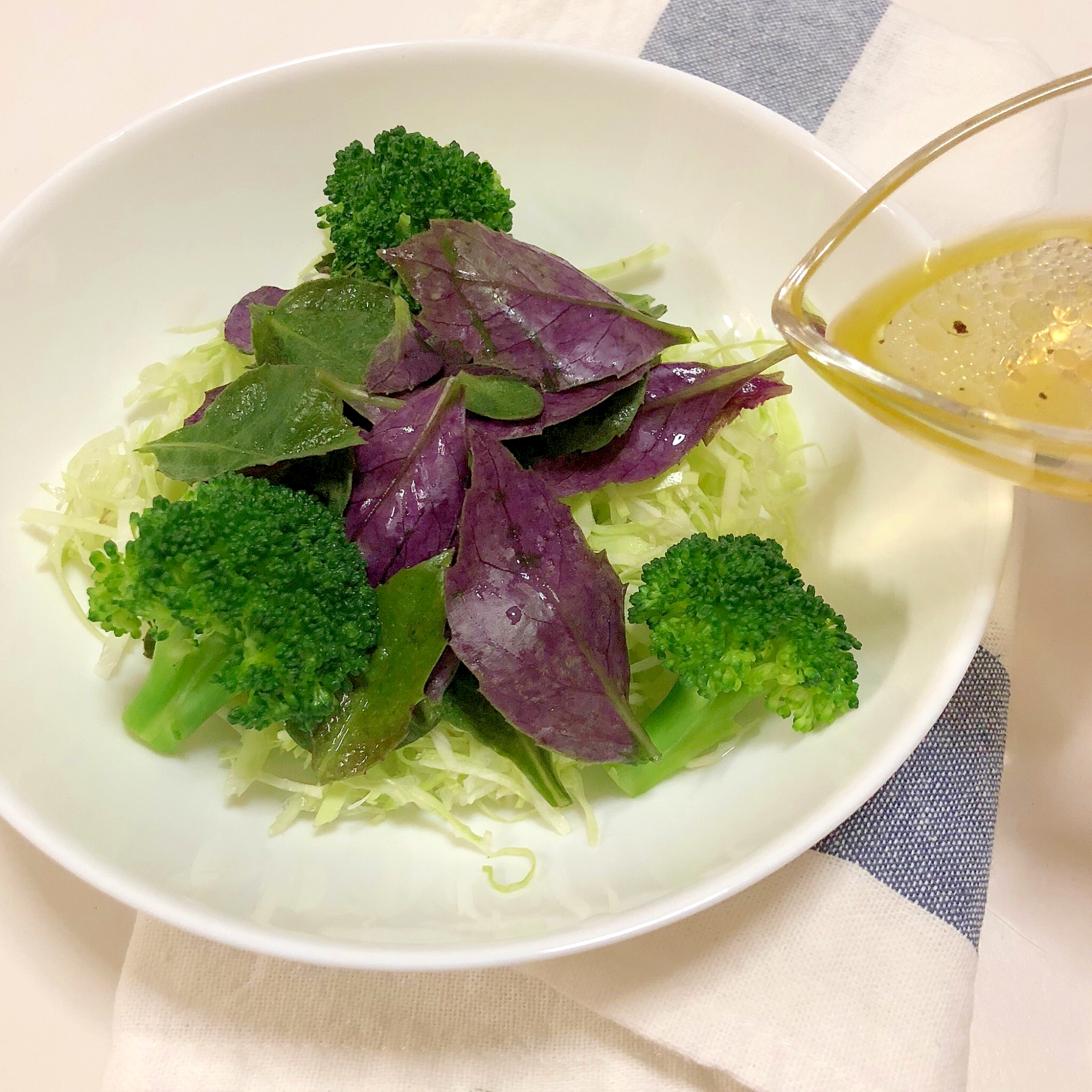 白い丸皿に盛り付けた金時草のサラダ