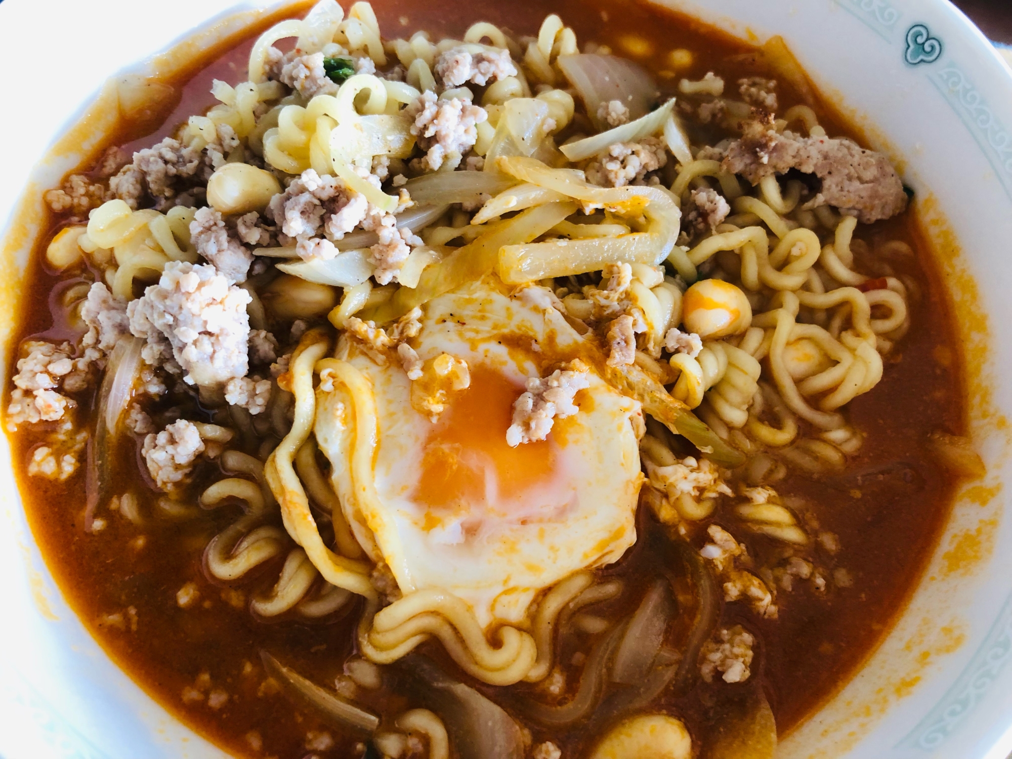 白い器に盛り付けた半熟卵と豚そぼろの辛ラーメン