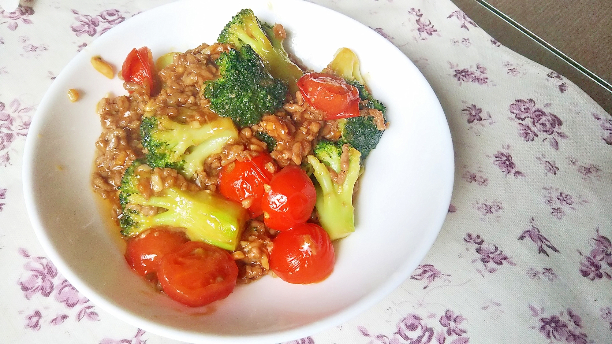 白い皿に盛られた、ブロッコリーとトマトの簡単オイスターそぼろ炒め