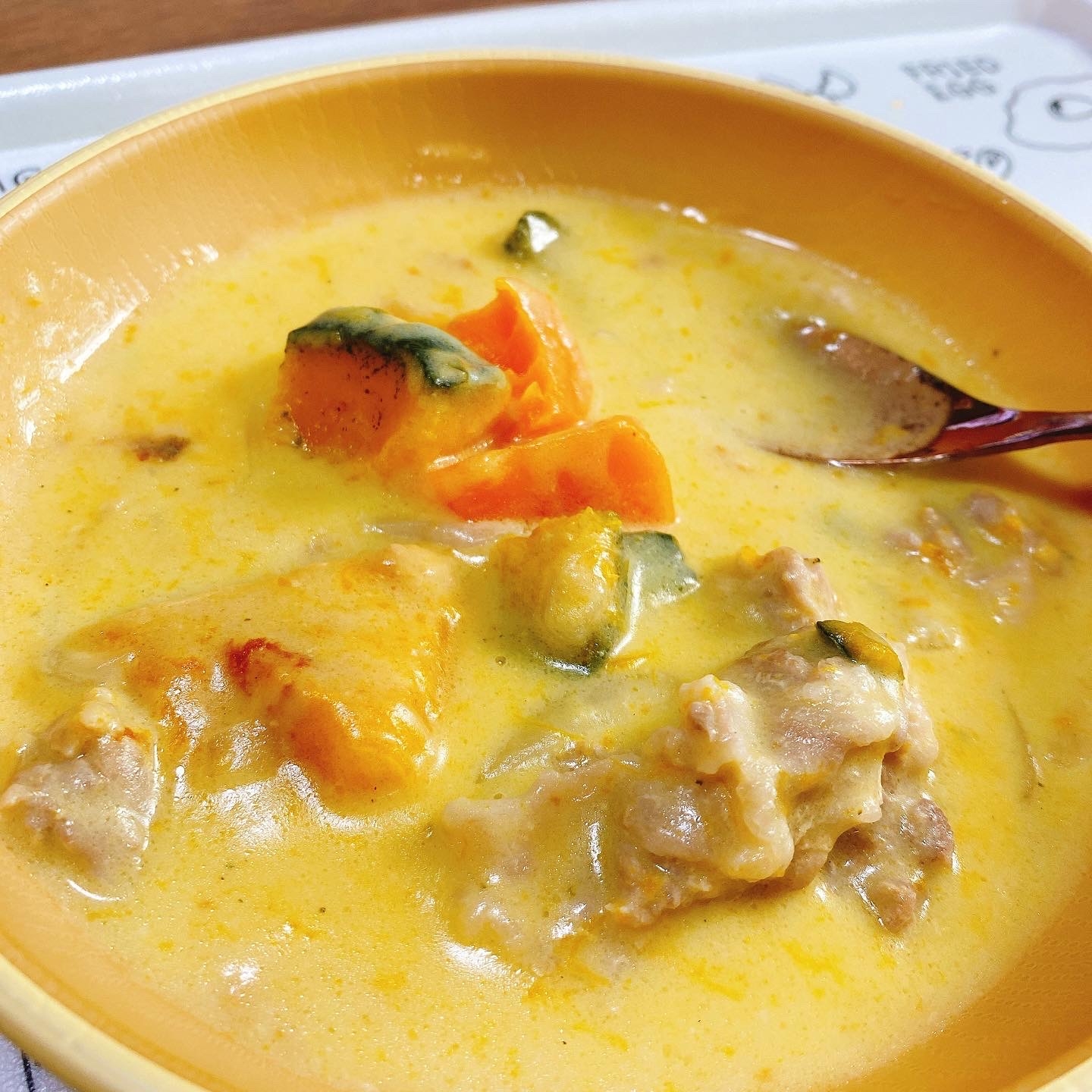 オレンジ色の器に盛られた、パンプキンシチュー