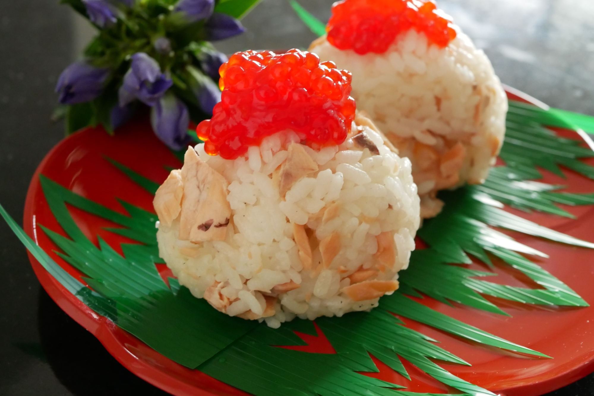 赤い皿に乗った筋子の親子おにぎり