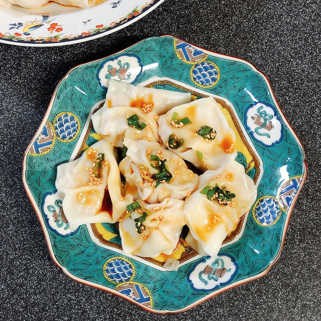 青緑の模様が鮮やかな皿に盛り付けた紅油水餃