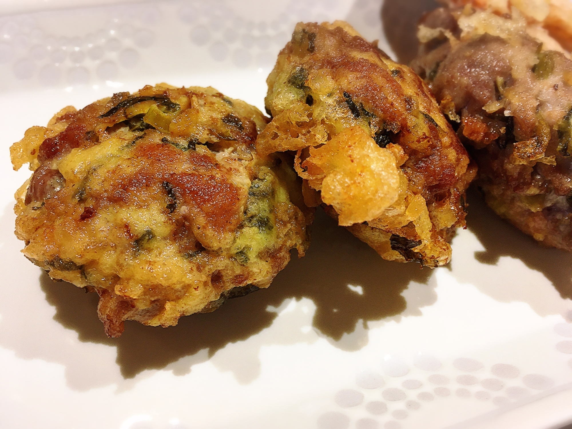 白いお皿に盛り付けられた豚こま肉と高菜漬けの天ぷら