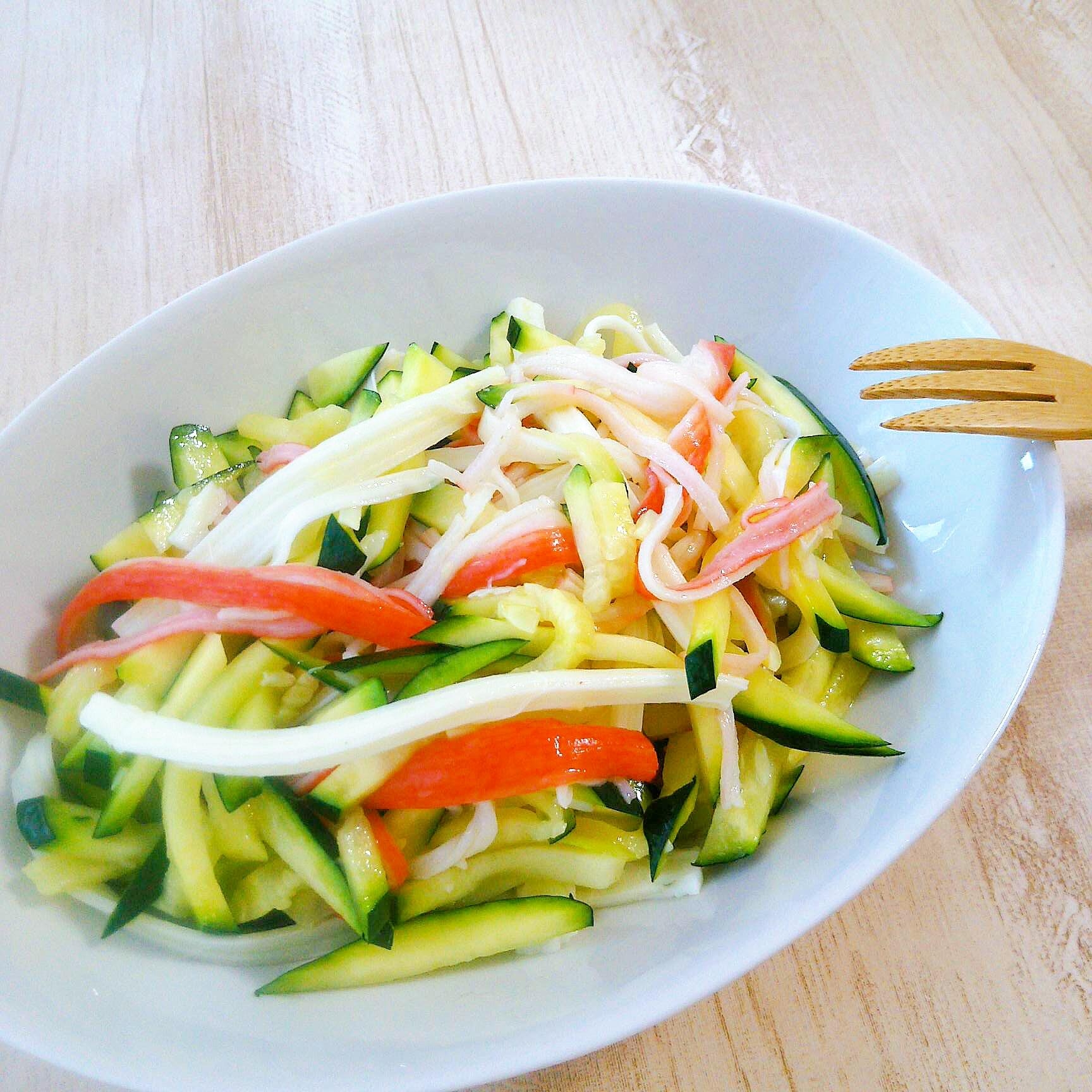 白い皿に盛られた、カニカマとズッキーニ、チーズのサラダ