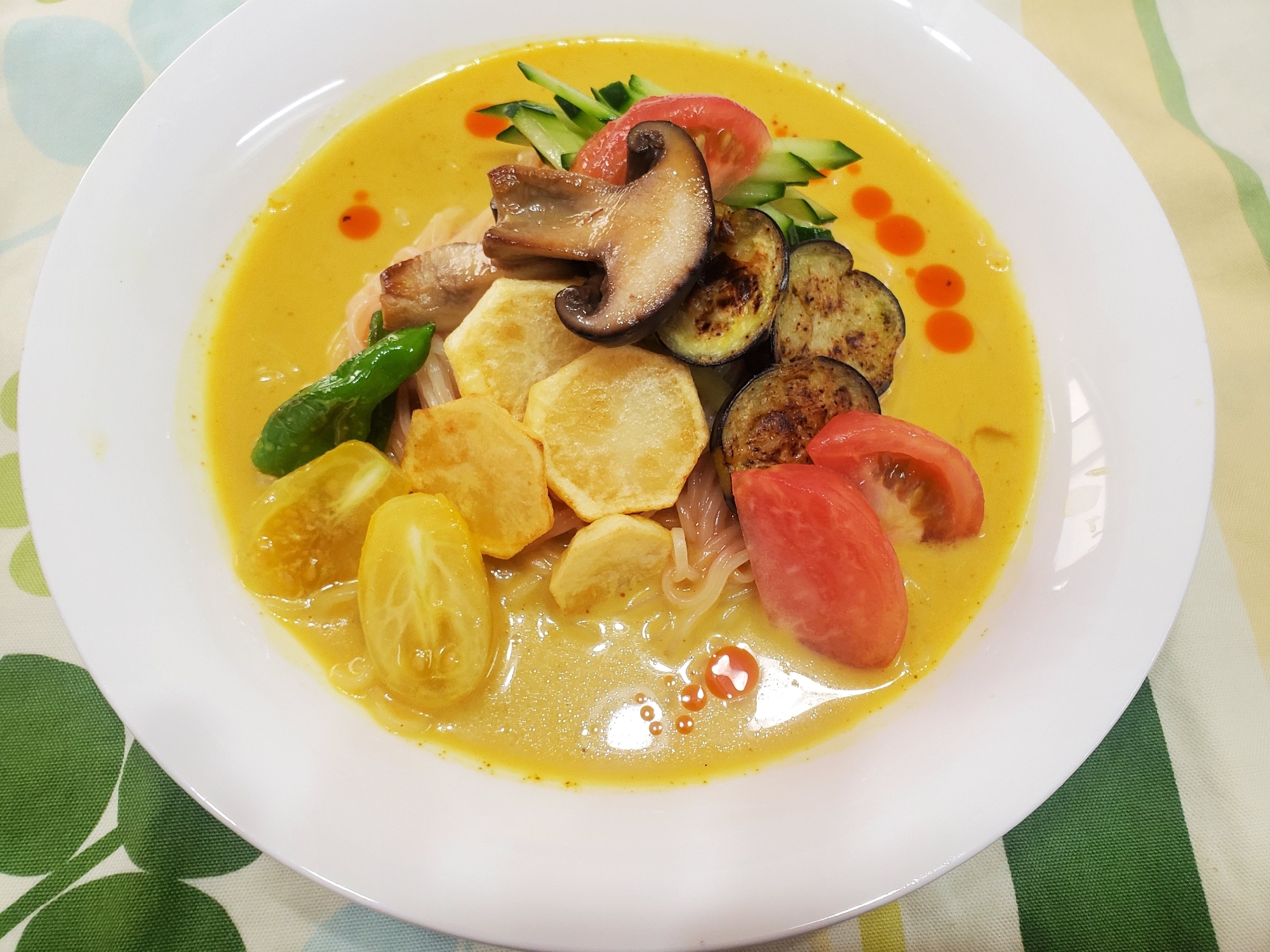 白い皿に入った焼き野菜の冷やしカレーラーメン