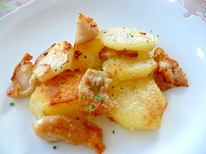 白い皿に盛られた鶏皮とじゃがいものガーリック炒め