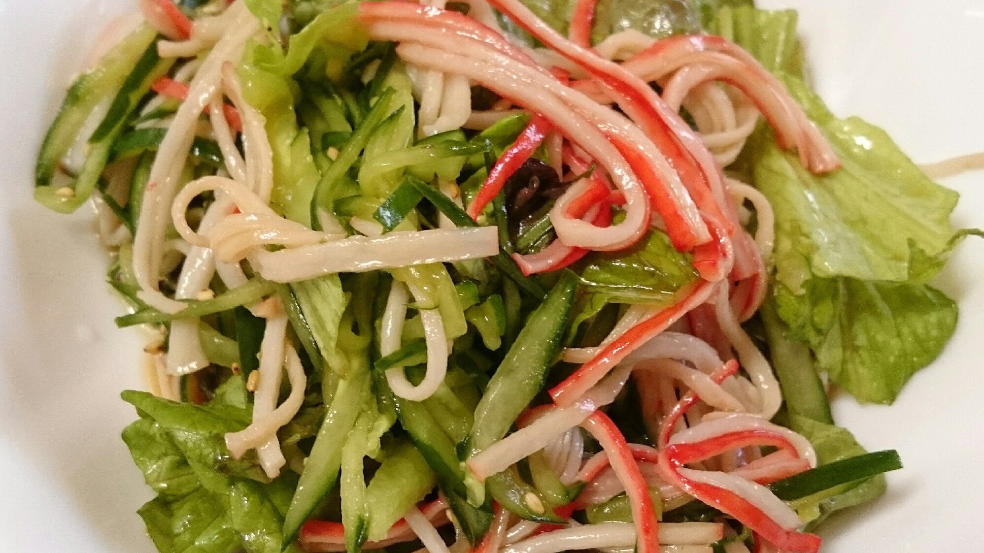 白いお皿に盛り付けられたきゅうりとカニカマとレタスの中華サラダ