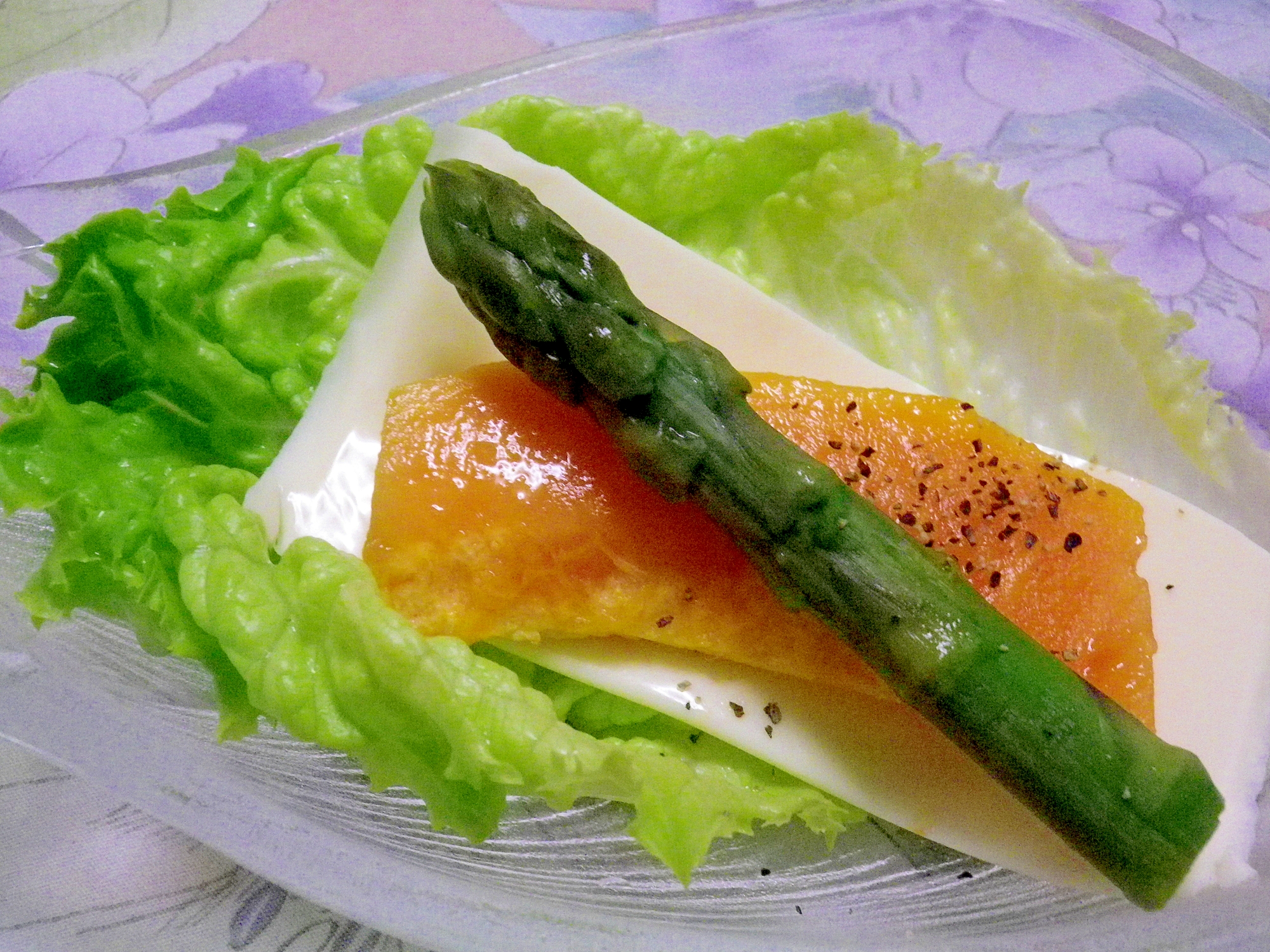 透明なお皿に盛り付けられたアスパラガスとパパイヤのゴーダチーズサラダ