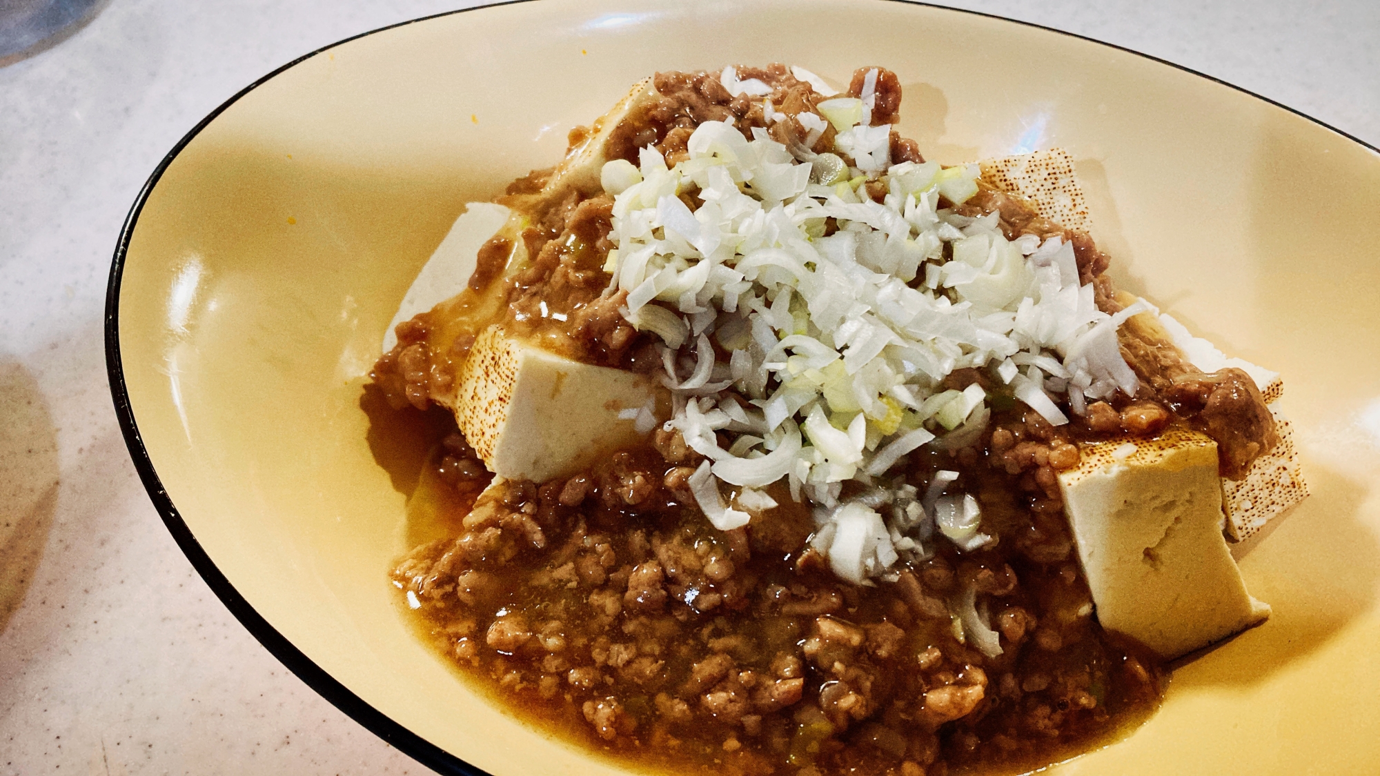 白い皿に盛りつけられた豚ひき肉入りあんかけ肉豆腐