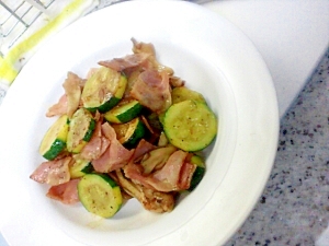 白色の丸皿に盛られたズッキーニとベーコン、まいたけの炒め物