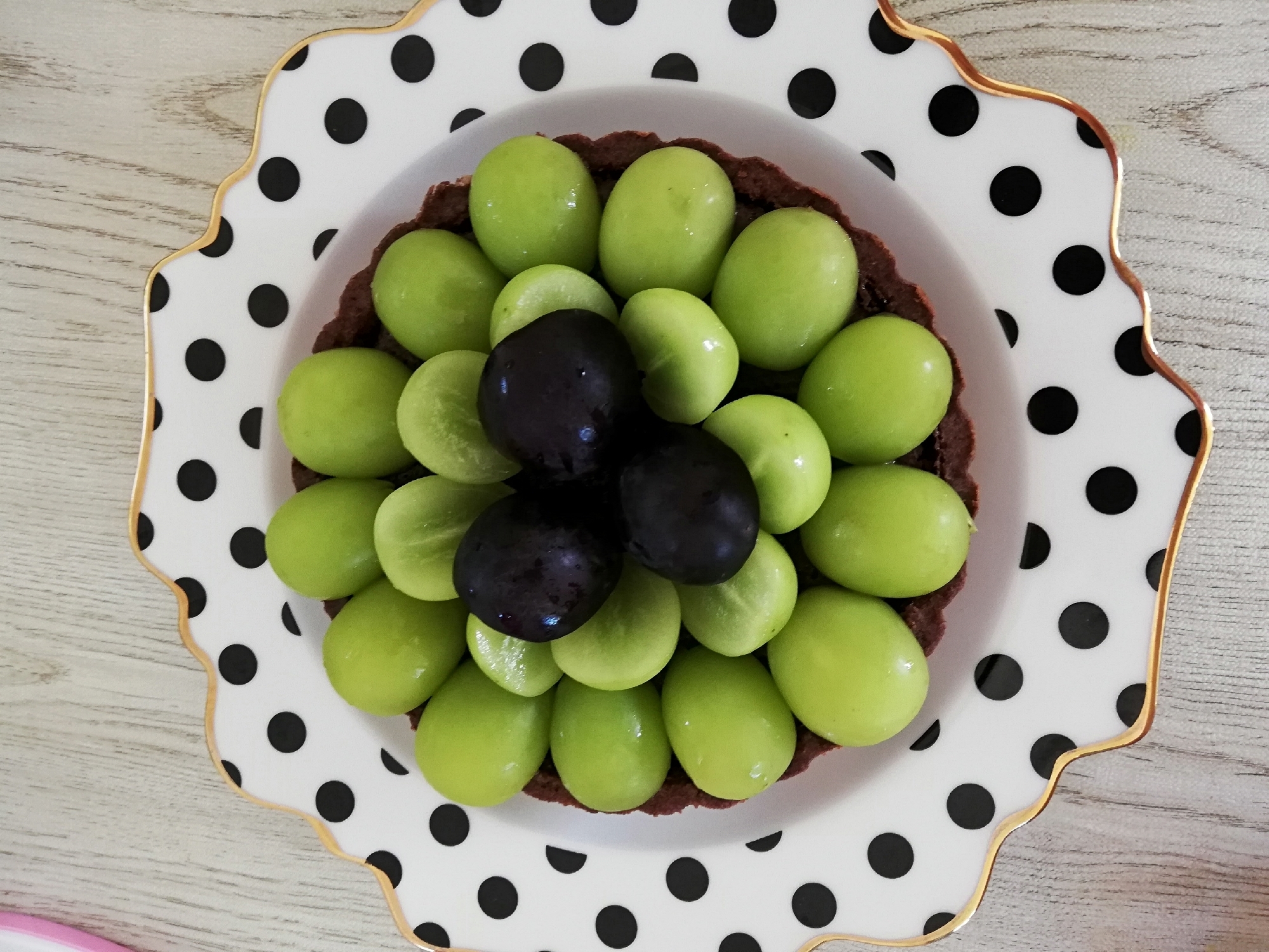 水玉の皿に盛られたシャンマスカットのチョコタルト